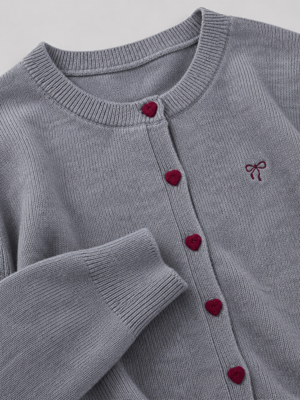 Women's knit cardigan with an embroidered bow and heart-shaped buttons