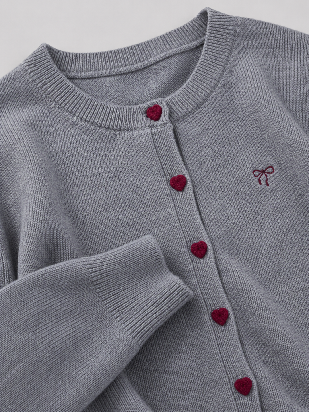 Women's knit cardigan with an embroidered bow and heart-shaped buttons